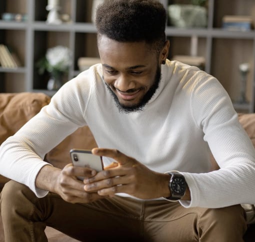 A smiling man looking at his phone