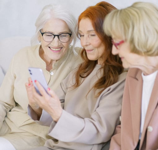 Three old friends looking at a smartphone